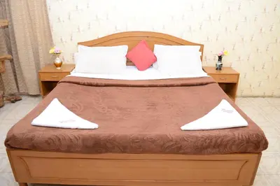 a bedroom with a large bed with two pillows at Rainbow Cottages-Budget Friendly rooms in Ooty