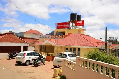 a restaurant with cars parked in front of a building at Rainbow Cottages-Budget Friendly rooms in Ooty