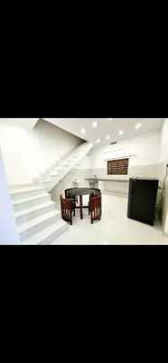 a dining room with a table and chairs and stairs at Mariya Stay in Kanjikode