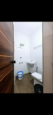 a bathroom with a toilet and a sink and a door at Mariya Stay in Kanjikode