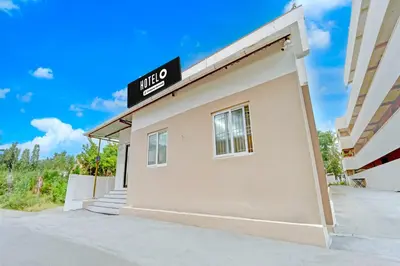 a building with a sign on the side of it at Hotel O Coimbatore Peelamedu Railway Station in Coimbatore