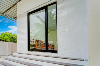 a window on the side of a white house at Hotel O Coimbatore Peelamedu Railway Station in Coimbatore