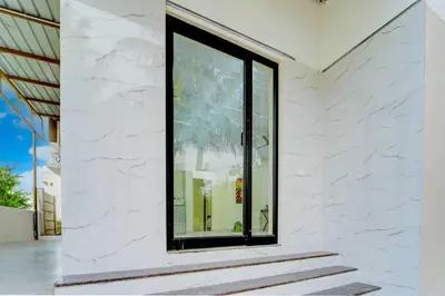 a window on the side of a white building at Hotel O Coimbatore Peelamedu Railway Station in Coimbatore