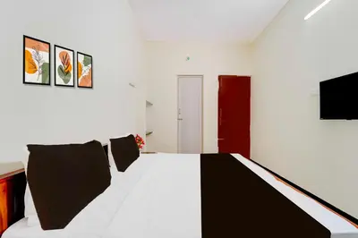 a bedroom with a black and white bed and a tv at Hotel O Coimbatore Peelamedu Railway Station in Coimbatore