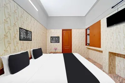 a bedroom with a large bed and a tv at Collection O Central Railway Station Tiruppur in Tiruppūr