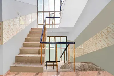 a staircase in a house with a blue railing at Collection O Central Railway Station Tiruppur in Tiruppūr