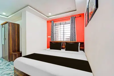 a bedroom with a bed with an orange wall at Collection O Ooty Government Rose Garden in Ooty