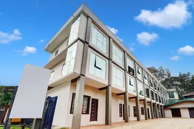 a white building with windows on the side of it at Collection O Waynad Near Sulthan Bathery in Wayanad