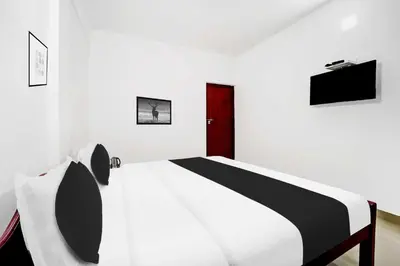 a bedroom with a black and white bed and a tv at Collection O Waynad Near Sulthan Bathery in Wayanad