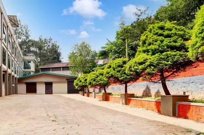 a street with trees on the side of a building at Collection O Waynad Near Sulthan Bathery in Wayanad