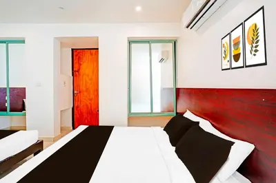 a bedroom with a white bed and a red wall at Collection O Teresian College Mysore in Mysore