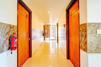 a hallway with two doors and a fire extinguisher at Collection O Teresian College Mysore in Mysore