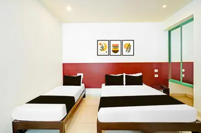 two beds in a room with red and white at Collection O Teresian College Mysore in Mysore