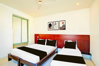 two beds in a room with a red headboard at Collection O Teresian College Mysore in Mysore