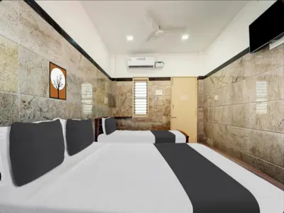 a bedroom with a large bed and a flat screen tv at Prm classic lodge in Erode