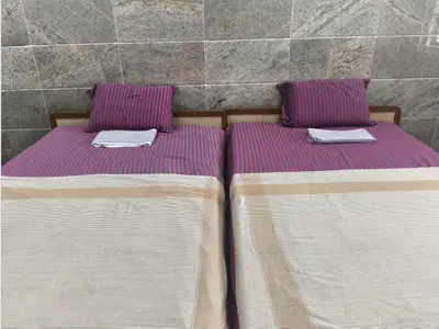two beds sitting next to each other in a room at Prm classic lodge in Erode