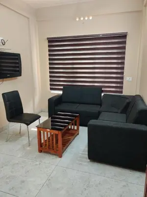a living room with a couch and a table and chairs at Dreams Arcade in Nedumbassery