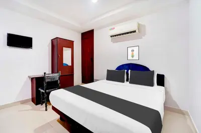 a bedroom with a bed and a desk in a room at Collection O Kunnamangalam Near Bus Stand in Kunnamangalam