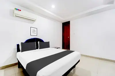 a white and black bed in a room at Collection O Kunnamangalam Near Bus Stand in Kunnamangalam