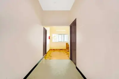 a corridor of an empty room with two doors at Collection O Ganapathy Athipalayam Pirivu Road in Coimbatore
