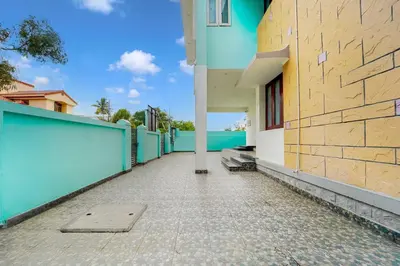 a sidewalk next to a building with a blue wall at Collection O Ganapathy Athipalayam Pirivu Road in Coimbatore