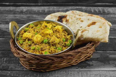a bowl of chicken and rice in a basket with a slice of bread at Collection O Erode VOC Park in Erode