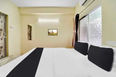 a bed in a room with a large window at Collection O Erode VOC Park in Erode