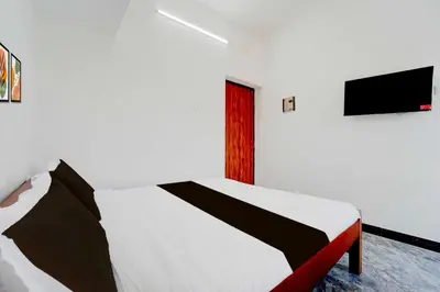 a bedroom with a bed and a tv on the wall at Collection O Neelambur Near PSG ITech in Irugūr