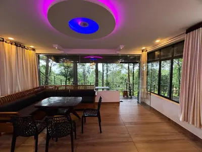 a living room with a table and a purple ceiling at Aambal Wayanad Pool House Resort by Veda Retreat in Wayanad