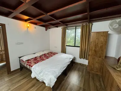 a bedroom with a bed and a window at Aambal Wayanad Pool House Resort by Veda Retreat in Wayanad