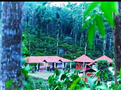 a resort with red roofs in the middle of a forest at THE DOCkSIDE INN in Madikeri