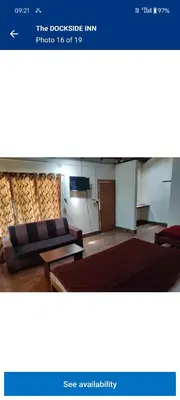 a view of a room with a couch and a tv at THE DOCkSIDE INN in Madikeri