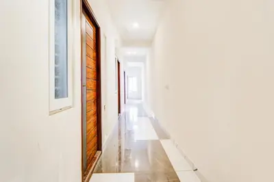 a hallway with white walls and a tile floor at Super Collection O RS Puram North Railway Station Formerly RG Residency in Coimbatore