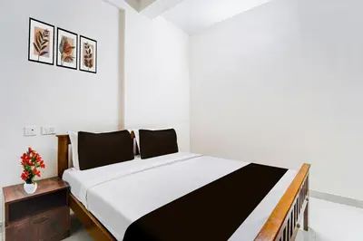 a bedroom with a black and white bed and a table at Super Collection O RS Puram North Railway Station Formerly RG Residency in Coimbatore