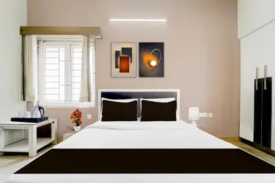 a bedroom with a large white bed and a window at Hotel O Ondipudur Bus Terminal Formerly New Paradise Inn in Irugūr