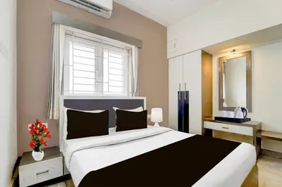 a bedroom with a large bed and a window at Hotel O Ondipudur Bus Terminal Formerly New Paradise Inn in Irugūr