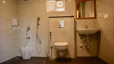 a bathroom with a shower and a toilet and a sink at Heritage Suites in Mysore