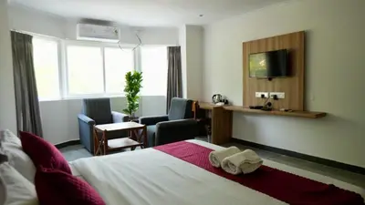 a hotel room with a bed and a desk at Heritage Suites in Mysore