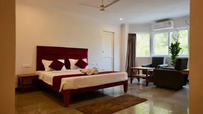 a bedroom with a large bed and a living room at Heritage Suites in Mysore