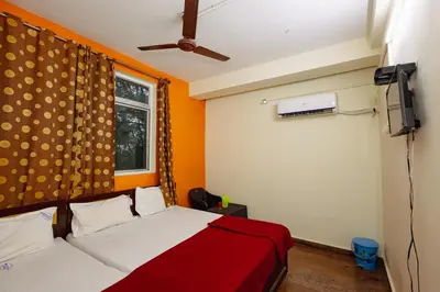 a bedroom with a bed and a tv and a window at Pvt Residency in Palani