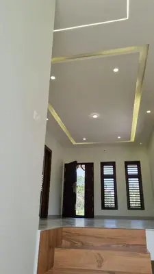 a living room with a wooden floor and windows at Little Home in Sultan Bathery