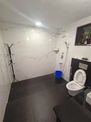 a bathroom with a toilet and a wall with cracks at Reevilla in Madikeri