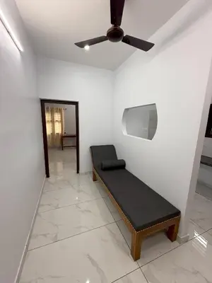 a room with a bench and a ceiling fan at Joseph's Residency Homestay in Podanūr