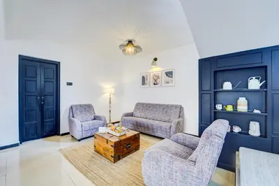 a living room with two chairs and a coffee table at Garden Haven 3 BHK Villa with Balcony and Verandah Escape in Kotagiri