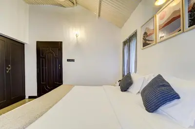 a bedroom with a large white bed with two pillows at Garden Haven 3 BHK Villa with Balcony and Verandah Escape in Kotagiri