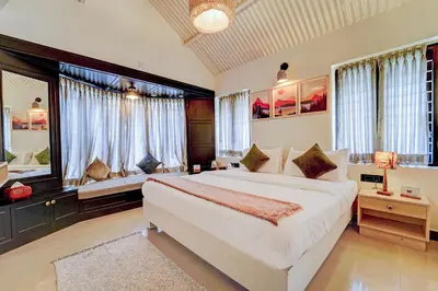 a large bedroom with a large bed and windows at Garden Haven 3 BHK Villa with Balcony and Verandah Escape in Kotagiri