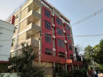 a red and white building on the side of a street at Aishvarya Residency in Coimbatore