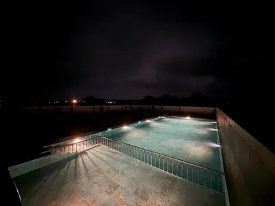 a swimming pool at night with lights on it at Leopard Hill Resort - Bandipur in Bandipūr