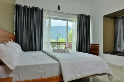 a bedroom with a bed and a large window at Banbury Bungalow in Kanthalloor