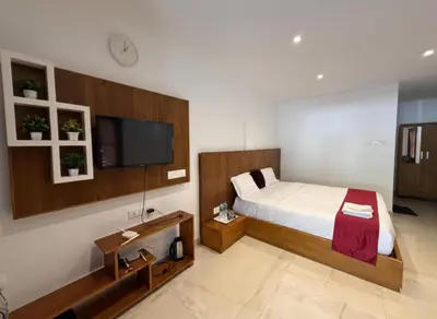 a bedroom with a bed and a flat screen tv at Forest Soul by BOB Hotels - Forest Retreat with Pool in Batheri